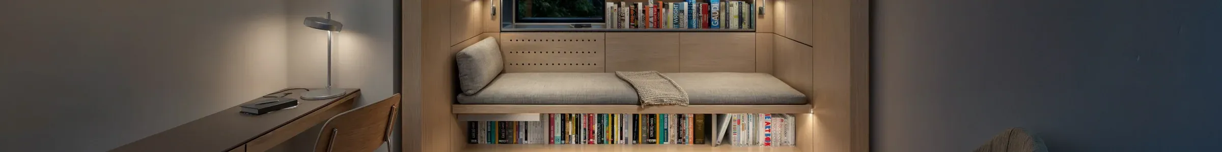 Custom wooden furniture with a built-in desk, window bench and recessed library.